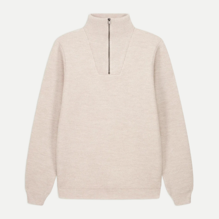 Pull camionneur beige clair en maille avec col montant et fermeture éclair noire au milieu.